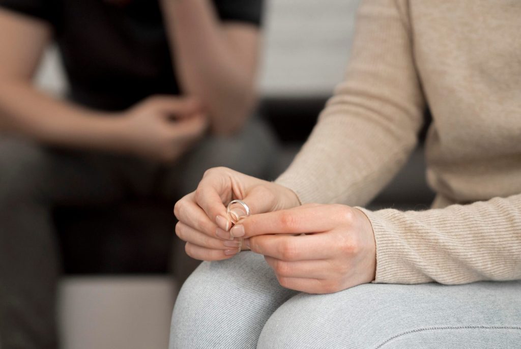Women holding an engagement ring while pondering the reasons for divorce